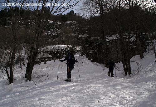 Climbing on hard wet snow through forest