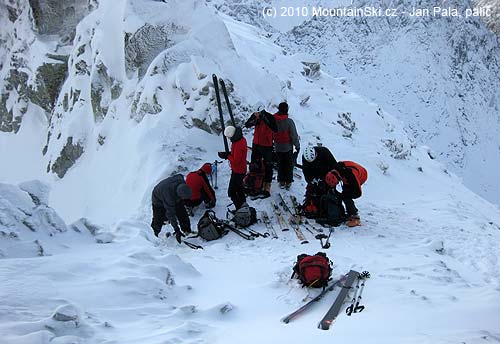 Celá skialpinistická skupina v Sedielku, vpravo do Zadné Javorové doliny jenom kamenná pole pokrytá malou vrstvou sněhu