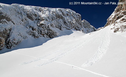 Samovolné laviny v kotli nad horní stanicí dlouhé lanovky, skialpová stopa vede přes laviniště