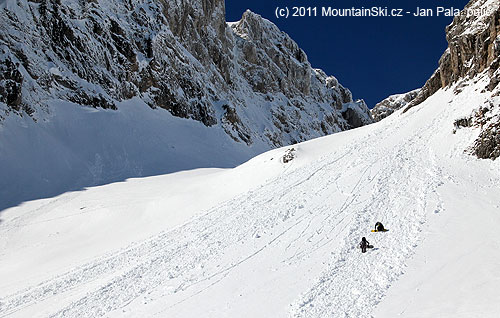 Dva snowboardisti se hrabou vzhůru laviništěm