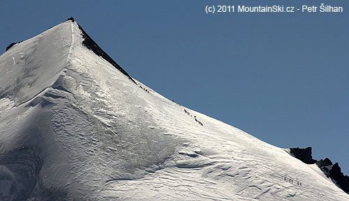 Davy skialpinistů stoupající za krásného počasí k vrcholu Allalinhornu