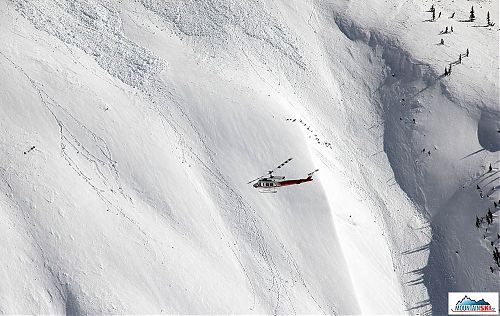 Our helicopter in the air, slopes behind are covered by avalanches