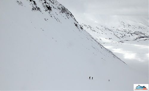 Skialpinisti v dolní části výstupu na Viljučinskij, vzadu v údolí most přes řeku Paratunka