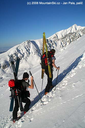 Připevnění širokých lyží bokem na batoh, výstup na Predné Solisko