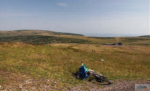 Výhled od památníku obětem hor (1509 m) na krkonošskou tundru s asfaltovou silnicí a Luční boudou (1410 m)